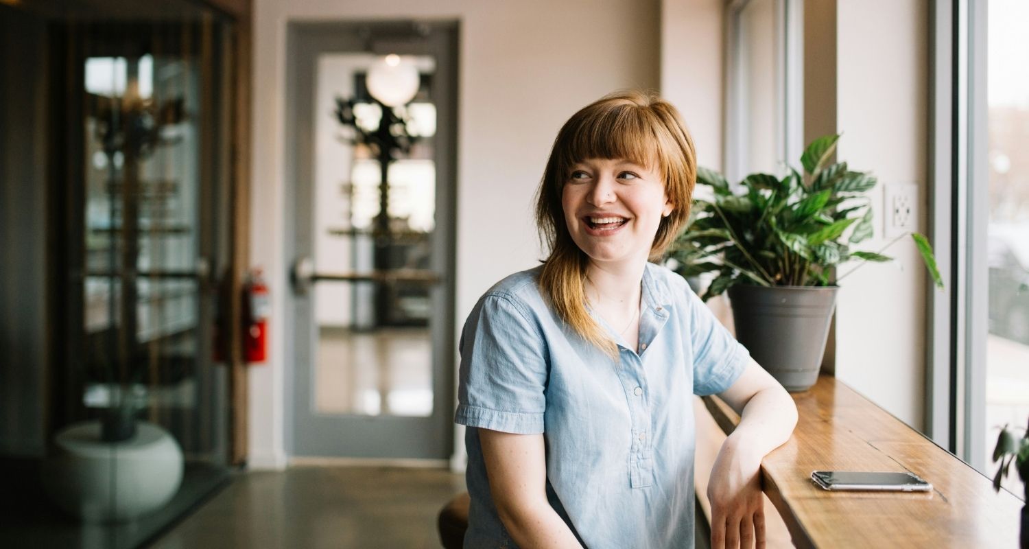 Jeune femme souriante assise à une table