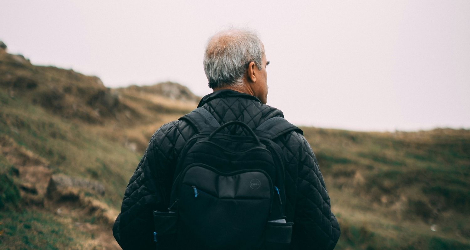 Homme en excursion dans un paysage accidenté.