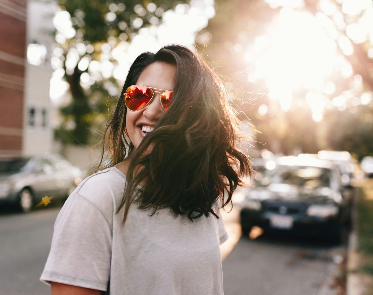 Femme heureuse dans une rue avec des lunettes de soleil